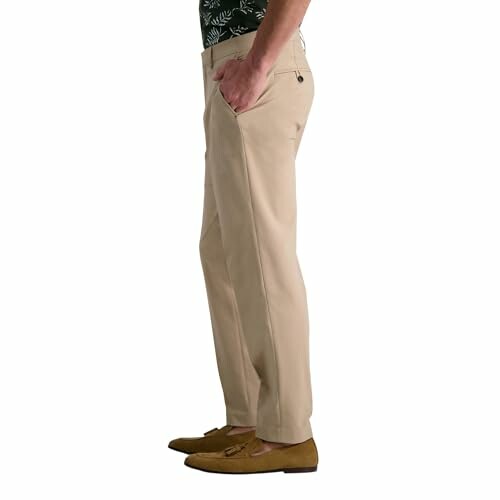 Side view of a person wearing beige trousers and brown shoes.