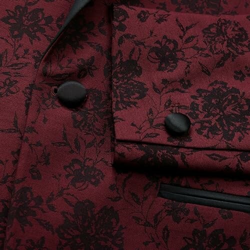 Close-up of a red jacket with black floral pattern and black buttons.